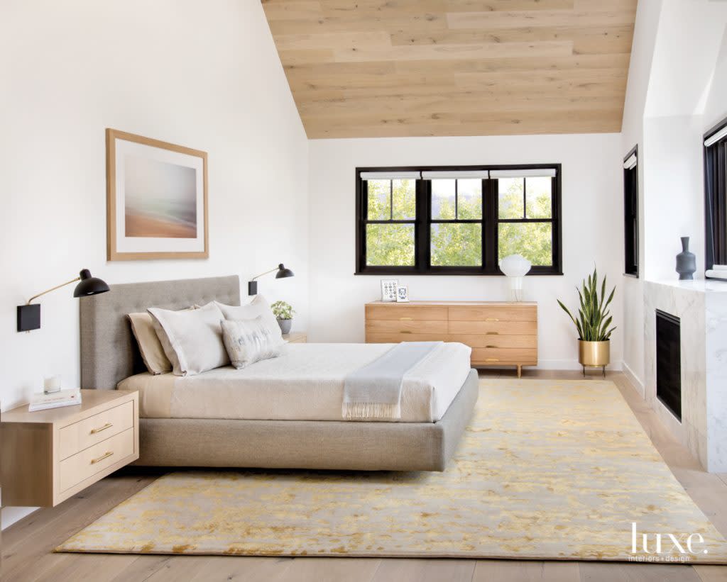 The goal in the master bedroom was to provide "comfort and luxury without it feeling fussy," McGuire says. The Poliform bed has linens from The Brass Bed. McGuire designed the floating bedside tables. The sconces are by Lambert & Fils, and the wool and silk Tibetan rug is from Organic Looms.