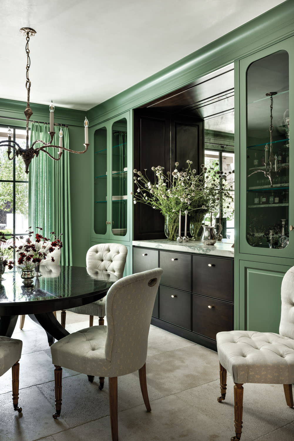 dining room with painted green walls, built in cabinetry and sideboard, round mahogany table and upholstered chairs by Marie Carson