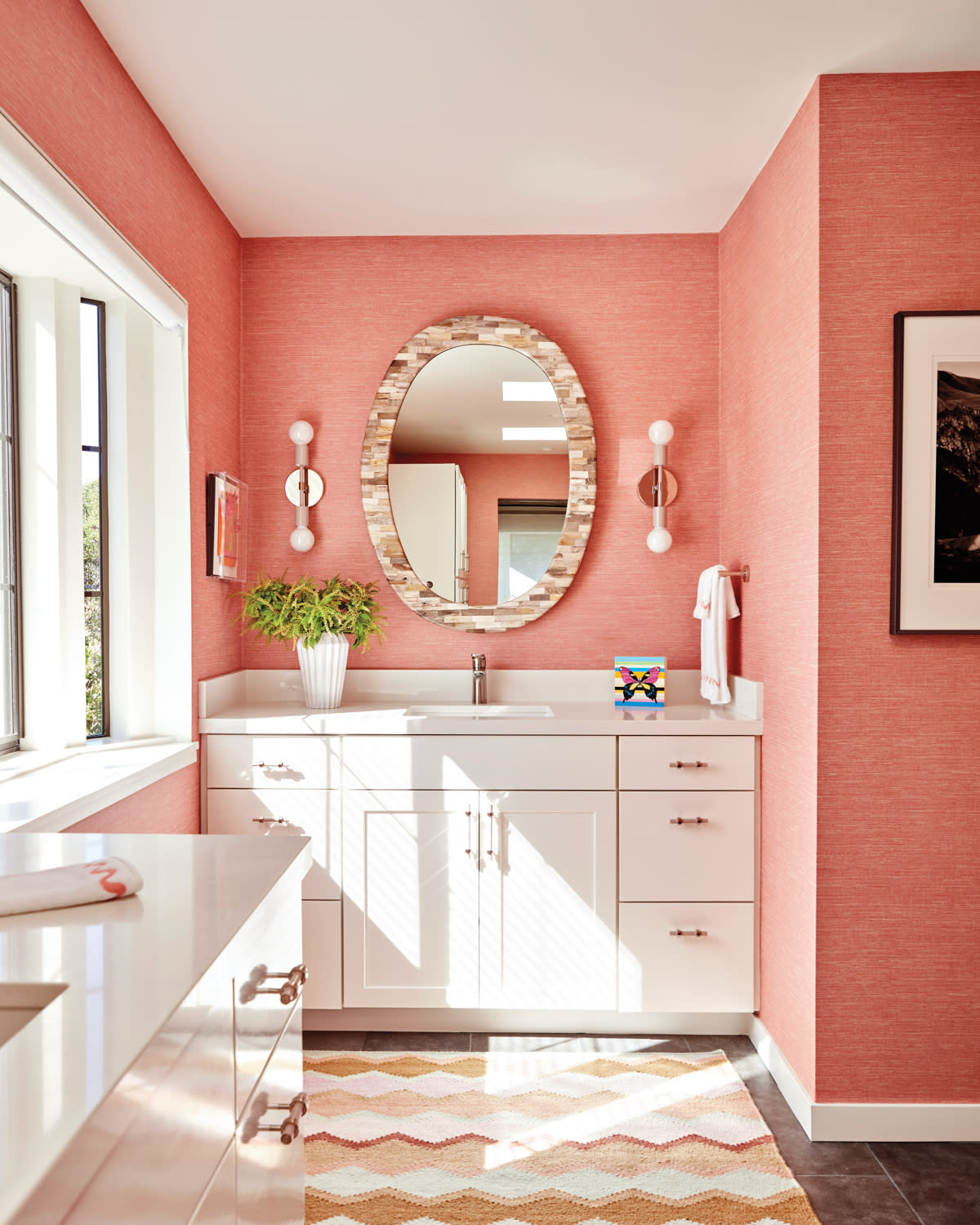 bathroom with a pink wallcovering and matching rug