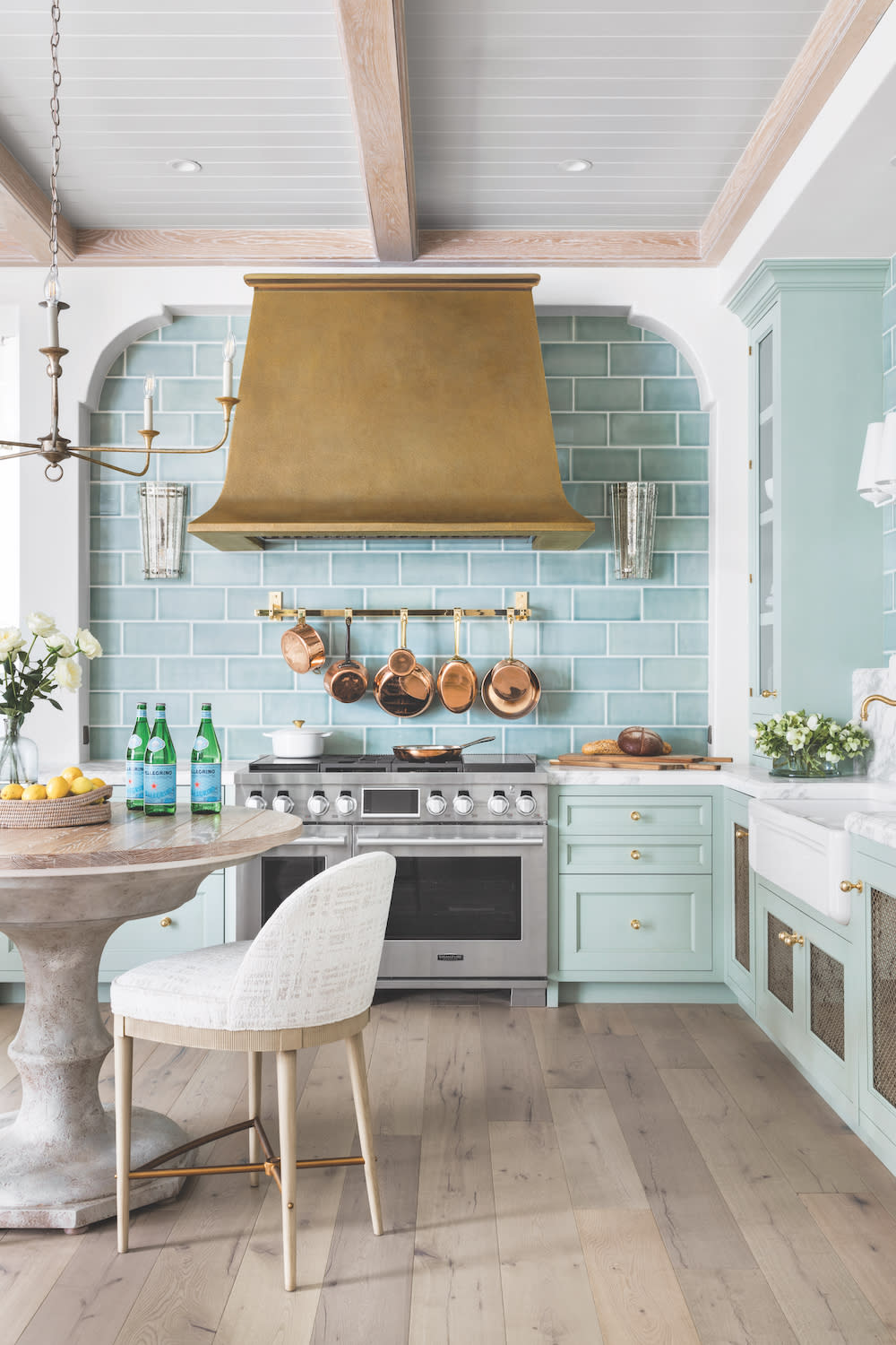 The Brassier Range Hood in open kitchen with teal blue tile backsplash and cabinets