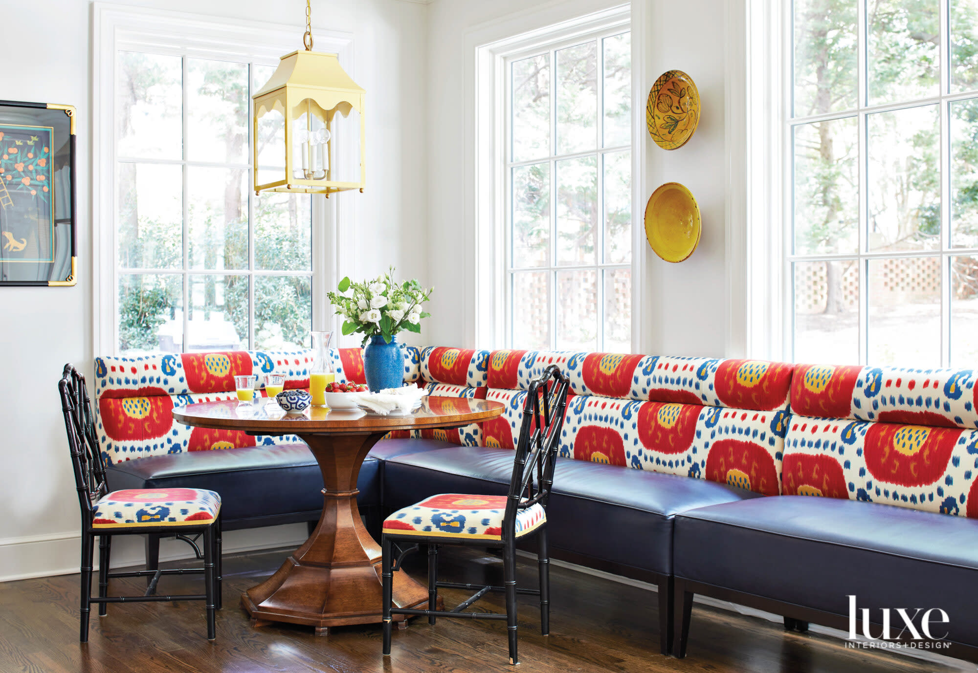 Corner of kitchen with windows, built-in banquette and round breakfast table