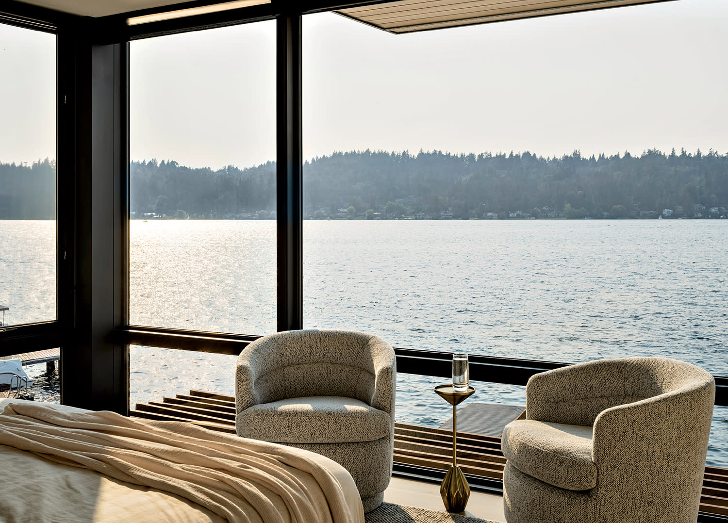 guest bedroom with chenille-covered swivel chairs in front of floor-to-ceiling windows 