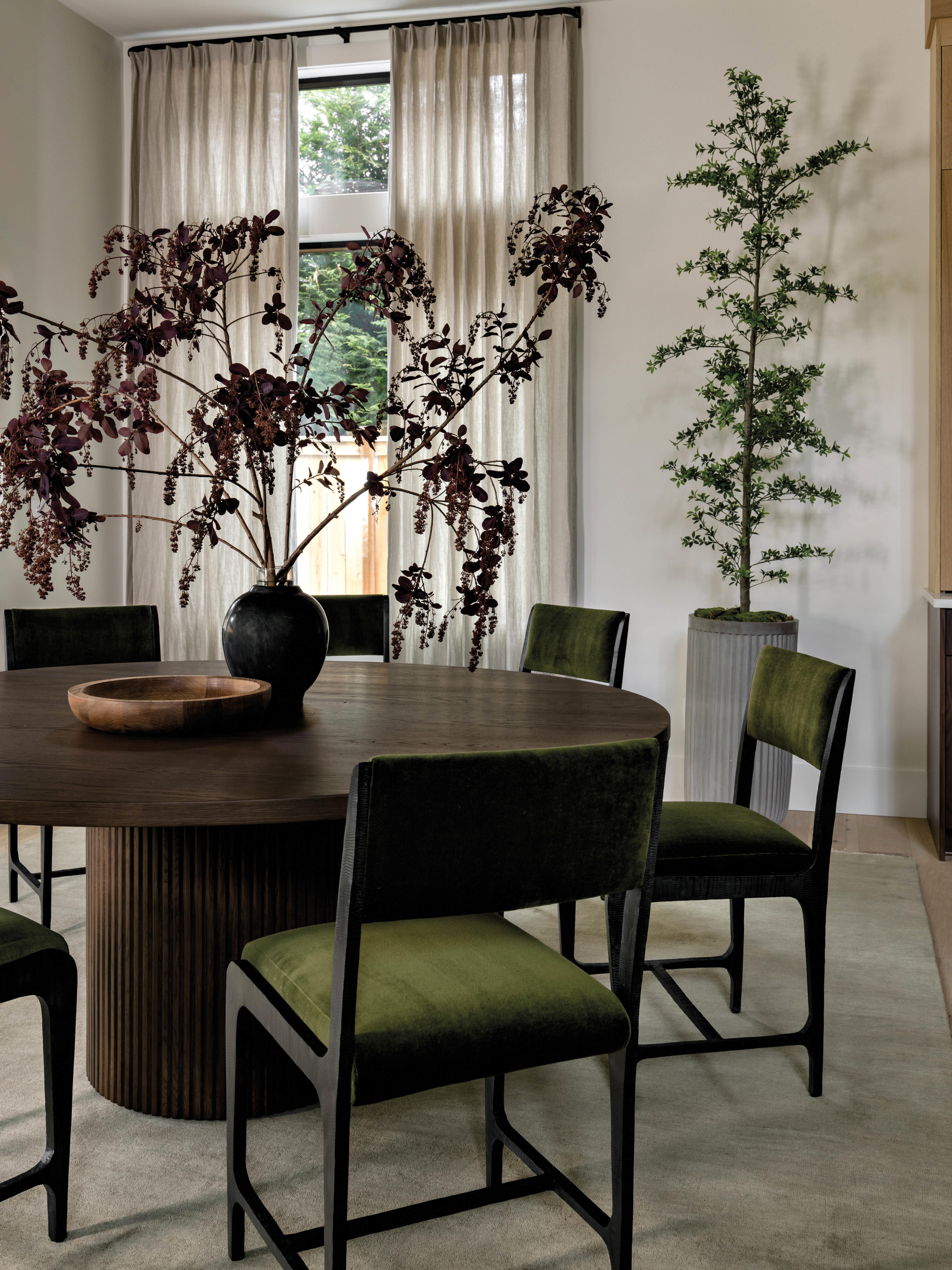 moody and dark breakfast room with green chairs around a circular table