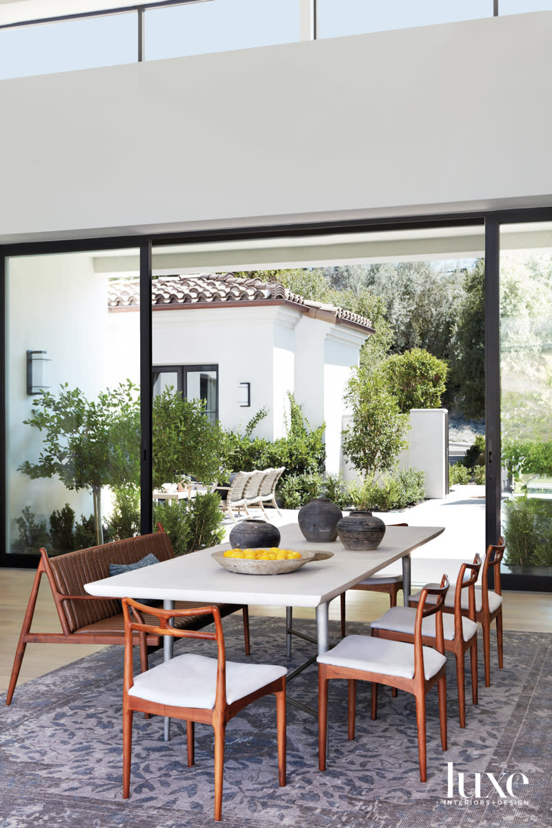 Dining room with table, chairs and bench and window beyond