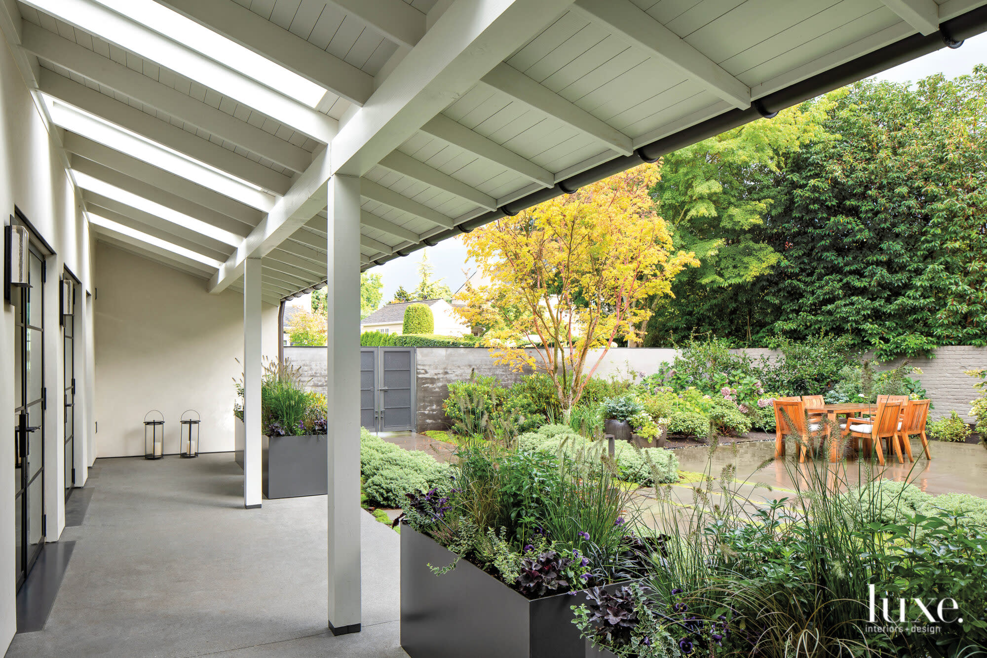 Covered terrace looking to dining area in forecourt of a house