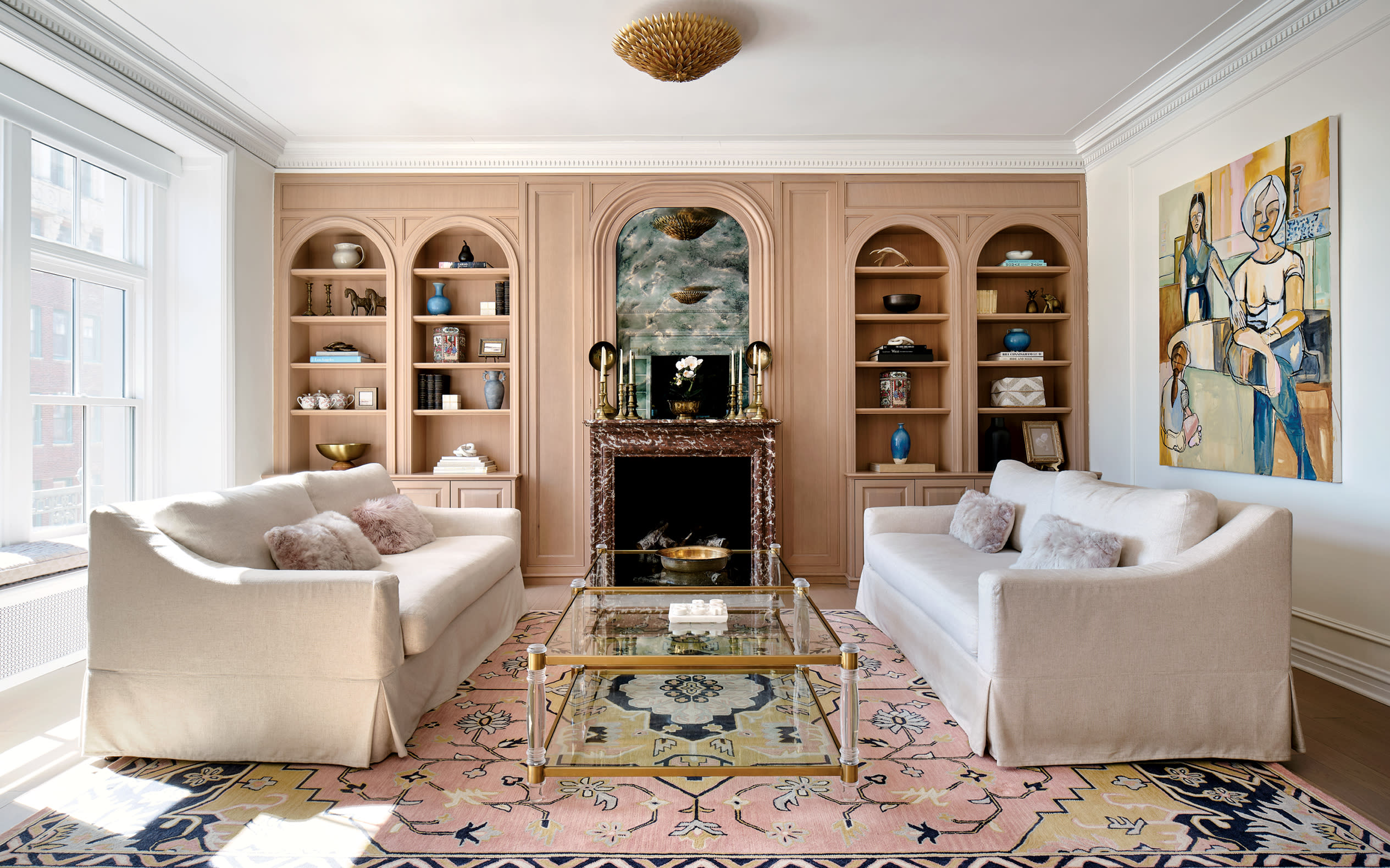 traditional living room with pink built-ins surrounding a marble fireplace