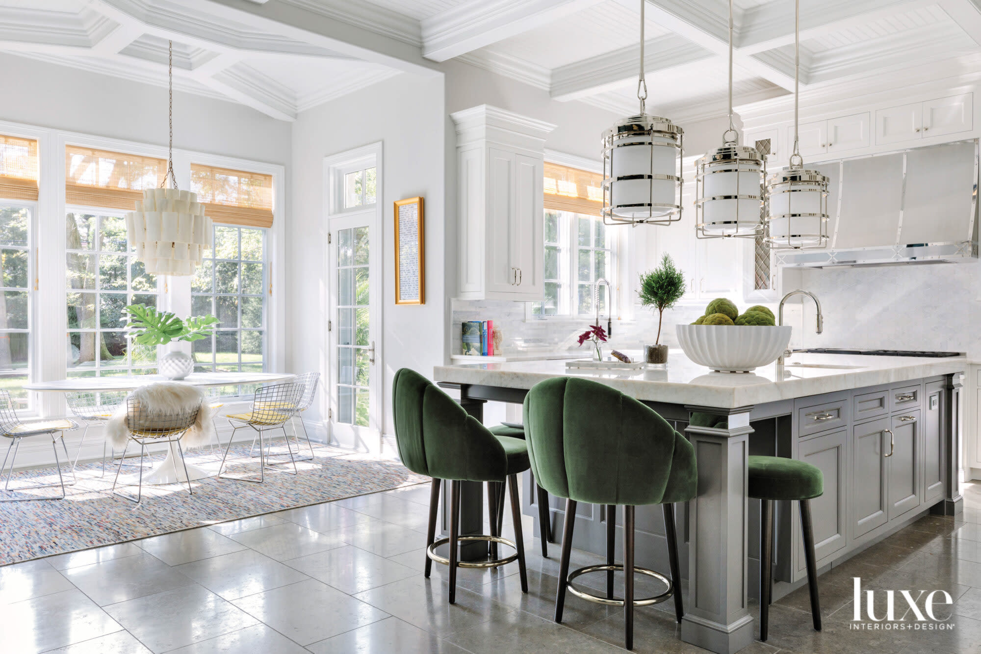 Dark green velvet stools sit next to the gray-and-white kitchen island.