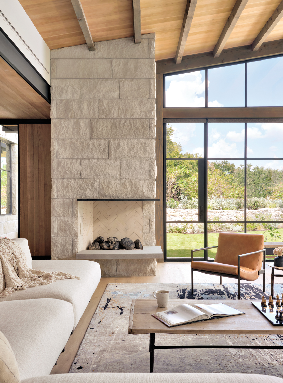 living room with a steel fireplace mantel, neutral furnishings and views of nature
