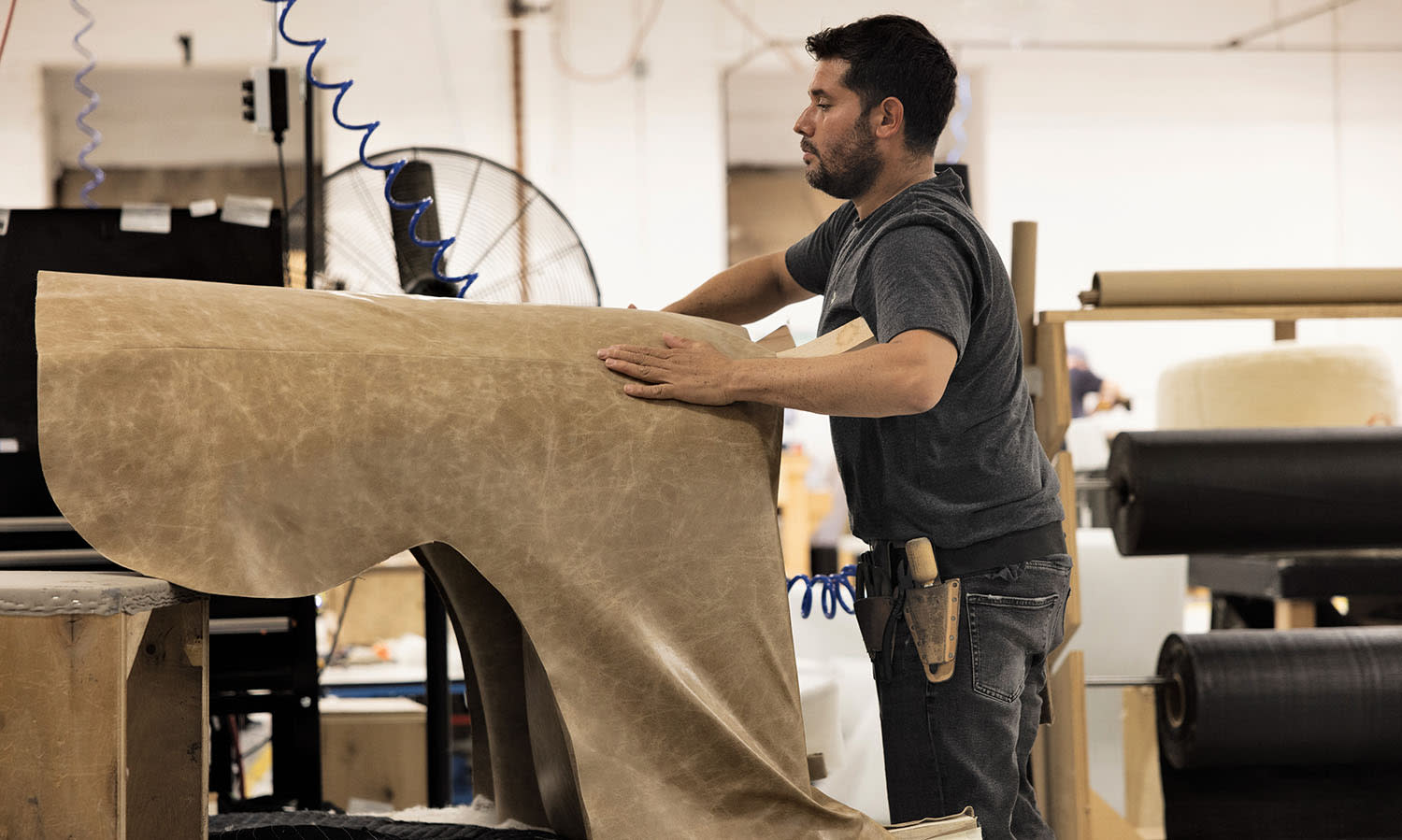 A man in a dark shirt works on furniture in the Verellen showroom.