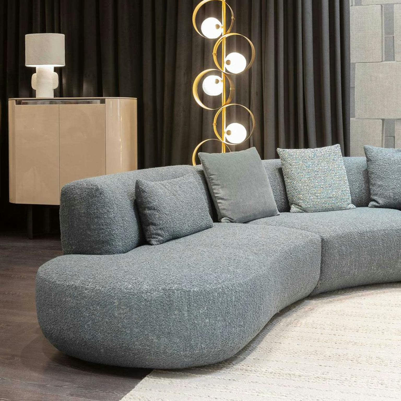 a couch in a furniture showroom with a statement light