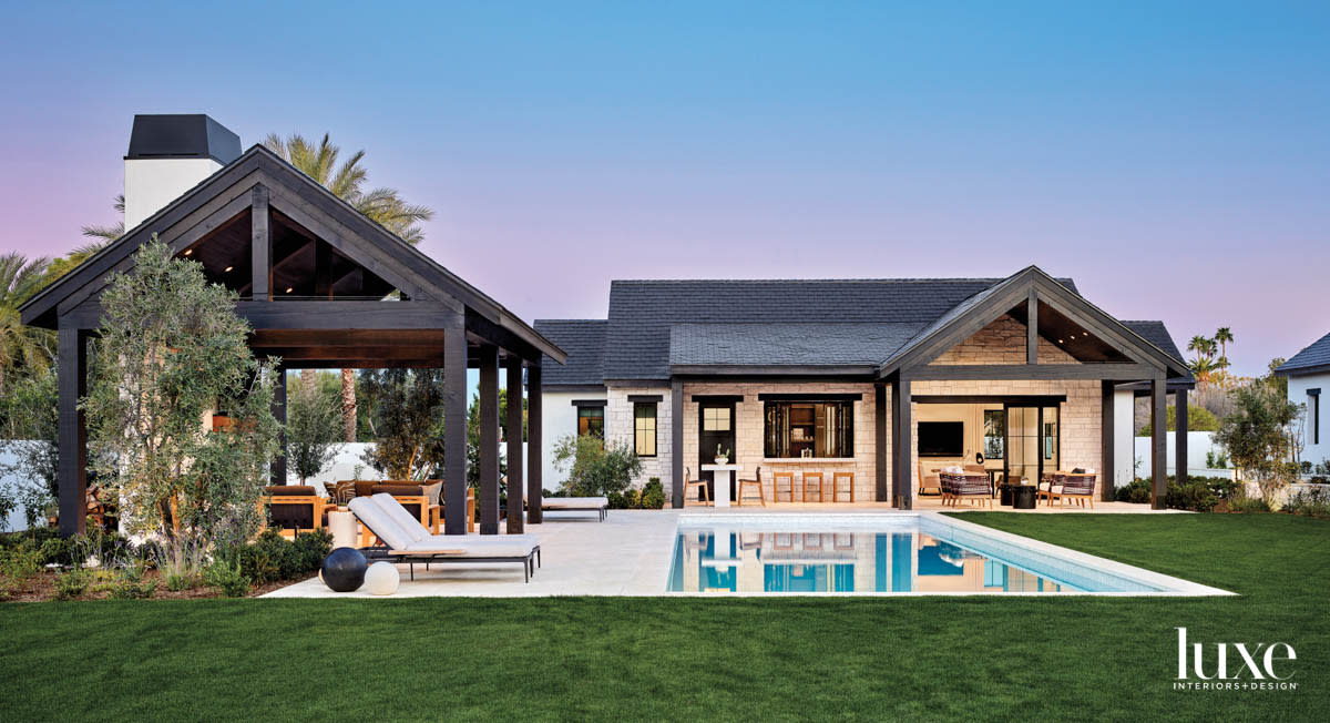 The backyard of a home with a pool at twilight.