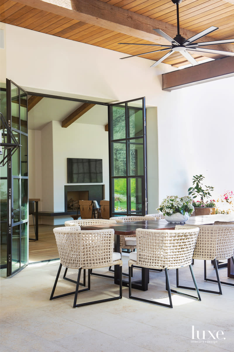 outdoor dining area with wood table and tidelli furnishings