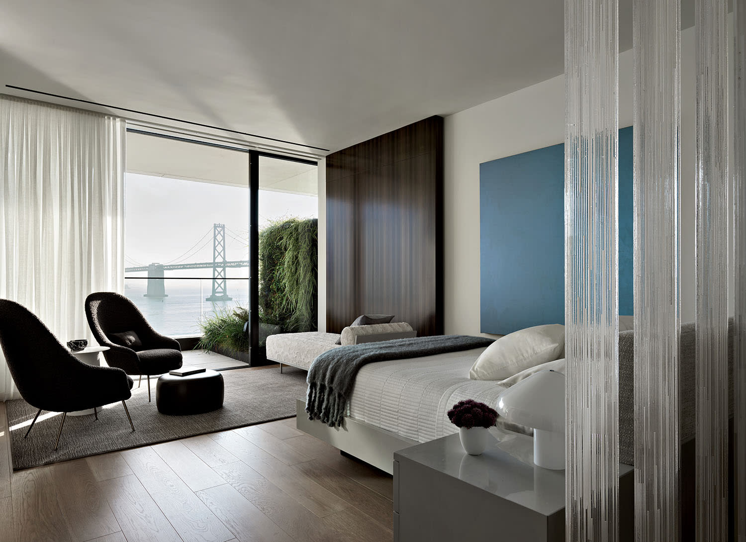 primary bedroom featuring a custom glass screen behind the bed