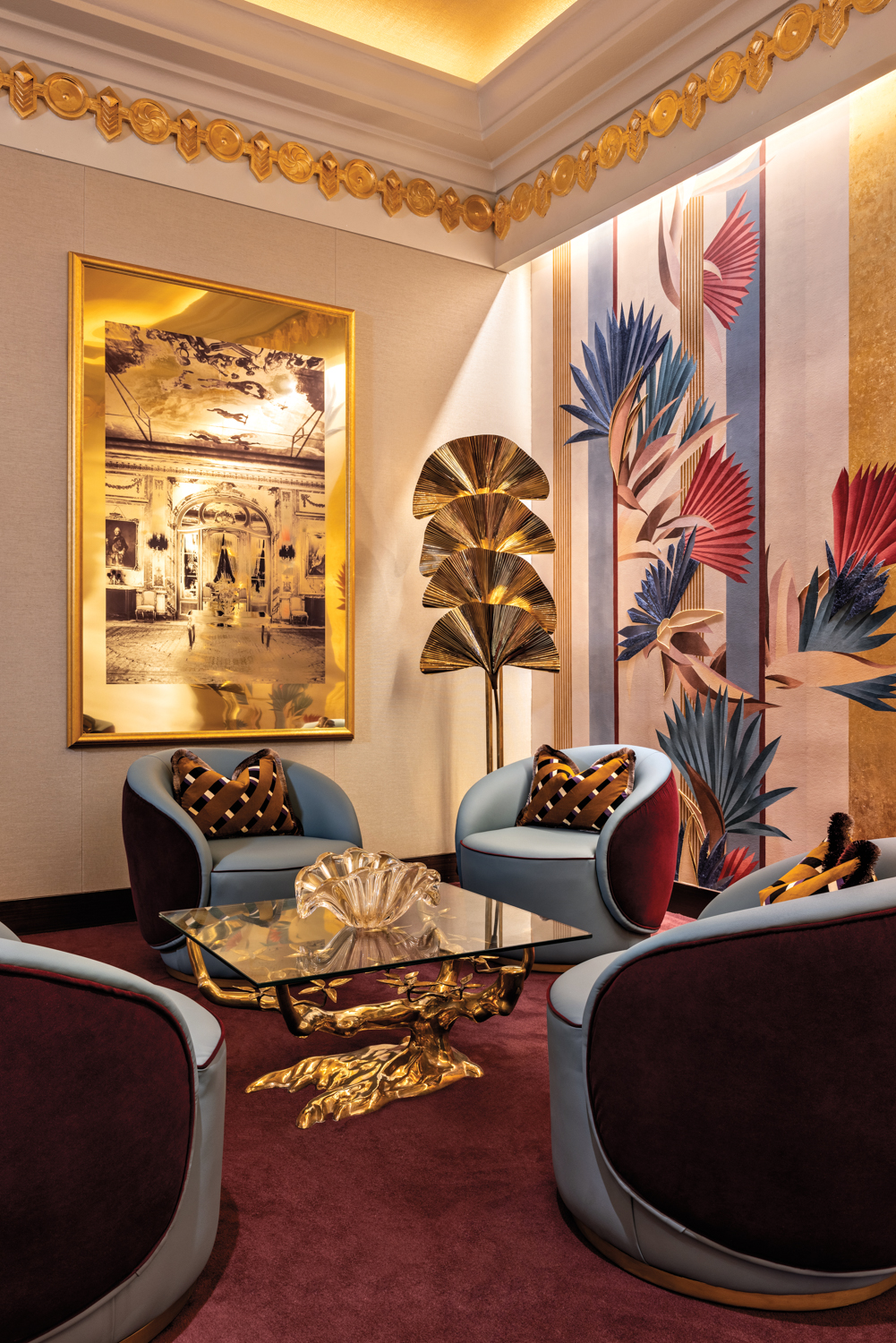 Art Deco-styled sitting area of four swivel chairs atop of maroon carpet with gold accents throughout