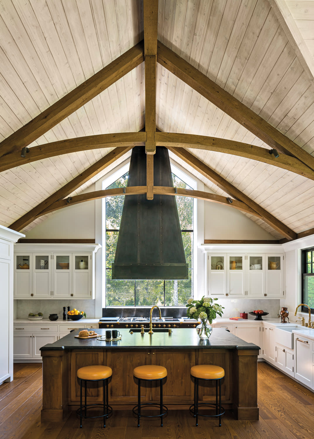 A modern kitchen featuring a center island and a large window that lets in natural light.