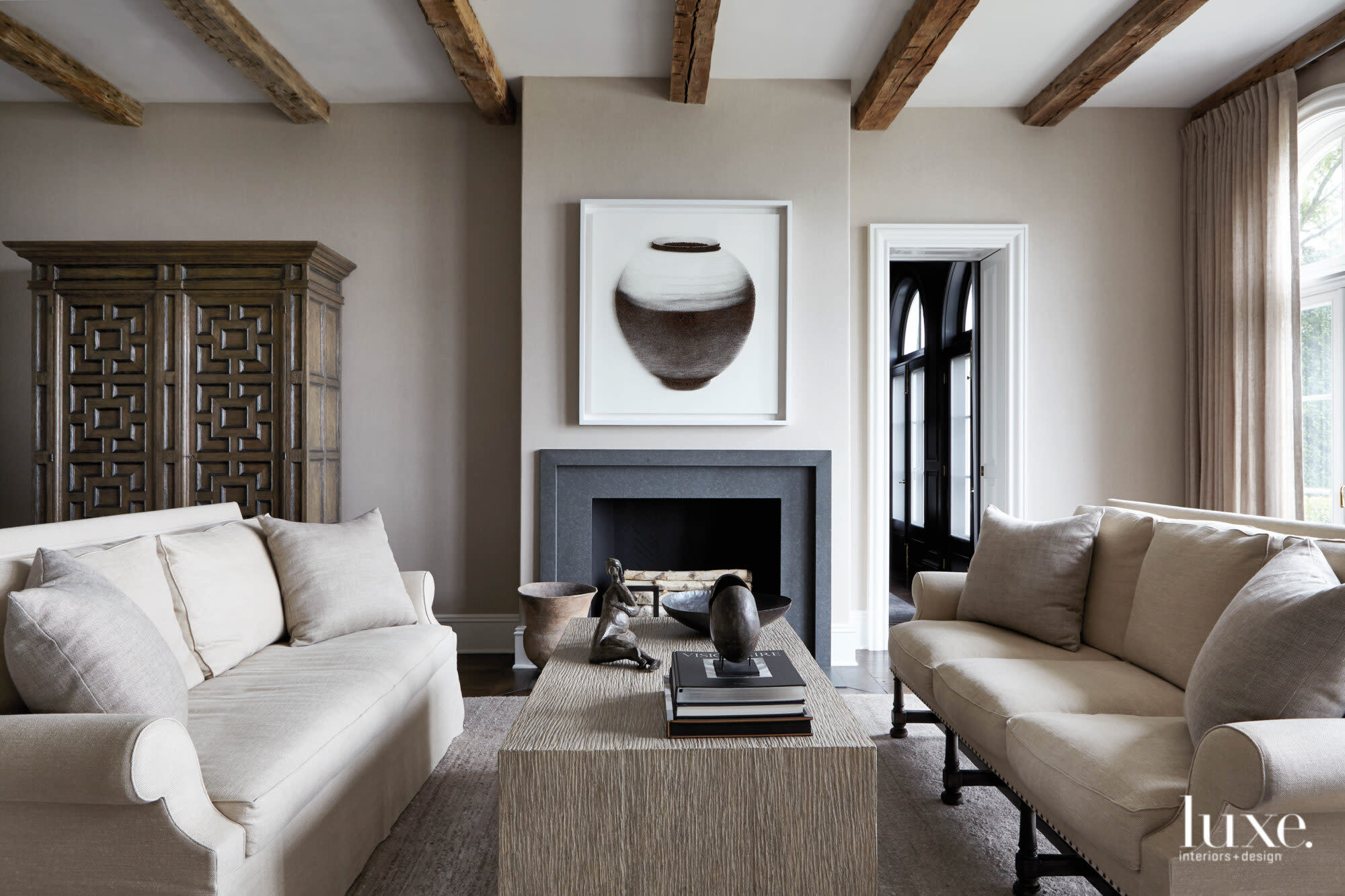 griege living room with beams and granite fireplace