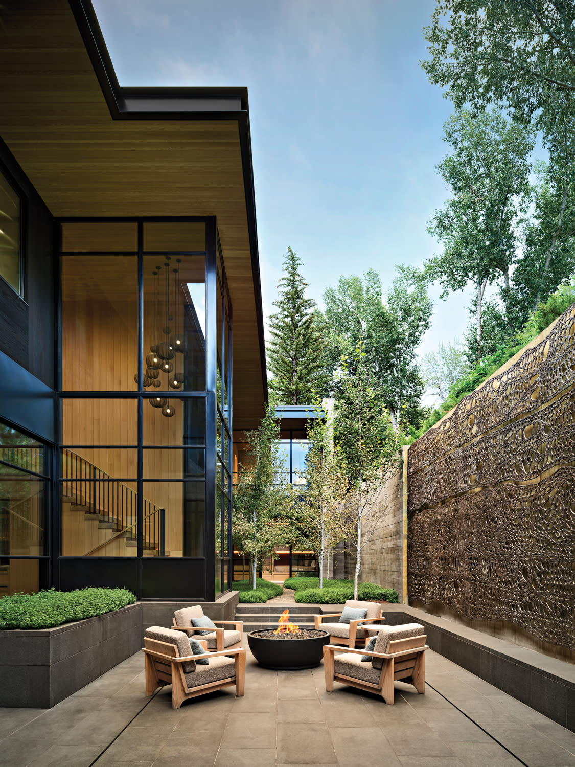 modern Colorado home's courtyard with a fire pit and bronze sculpture