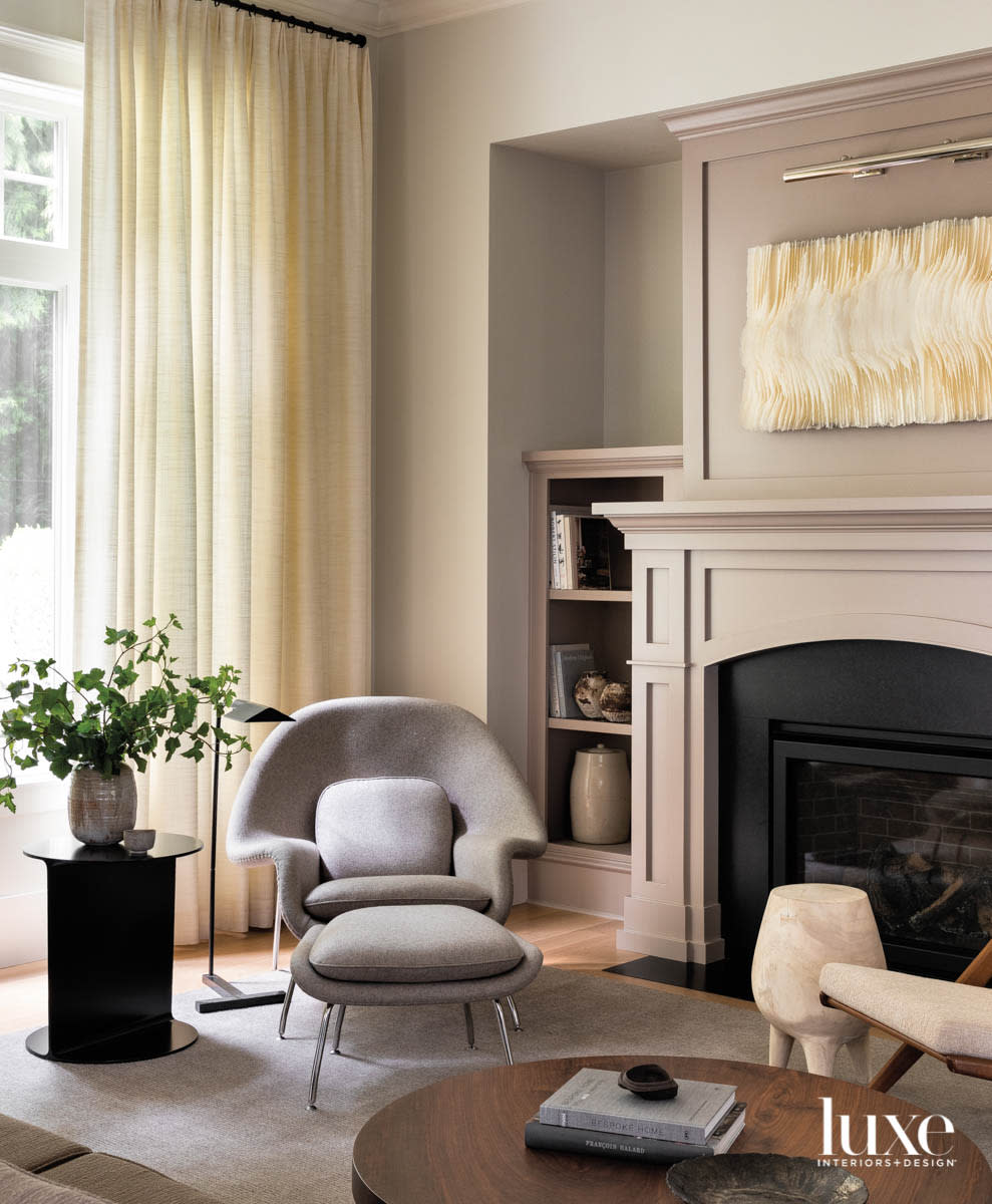 Detail shot of living room featuring lounge chair and ottoman and artwork above fireplace