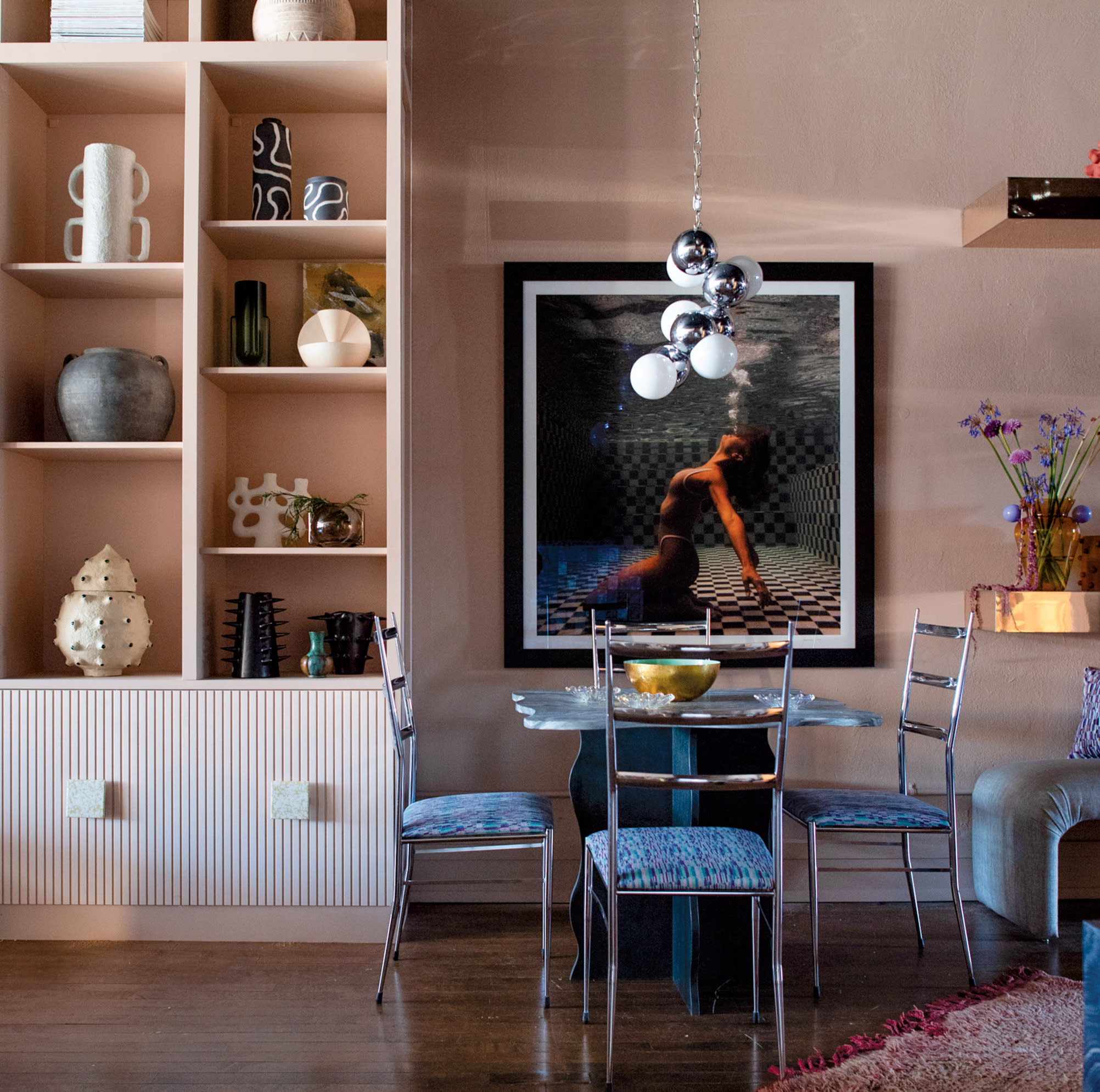 home goods store with a pink shelf featuring vases and an 80s-inspired framed photograph