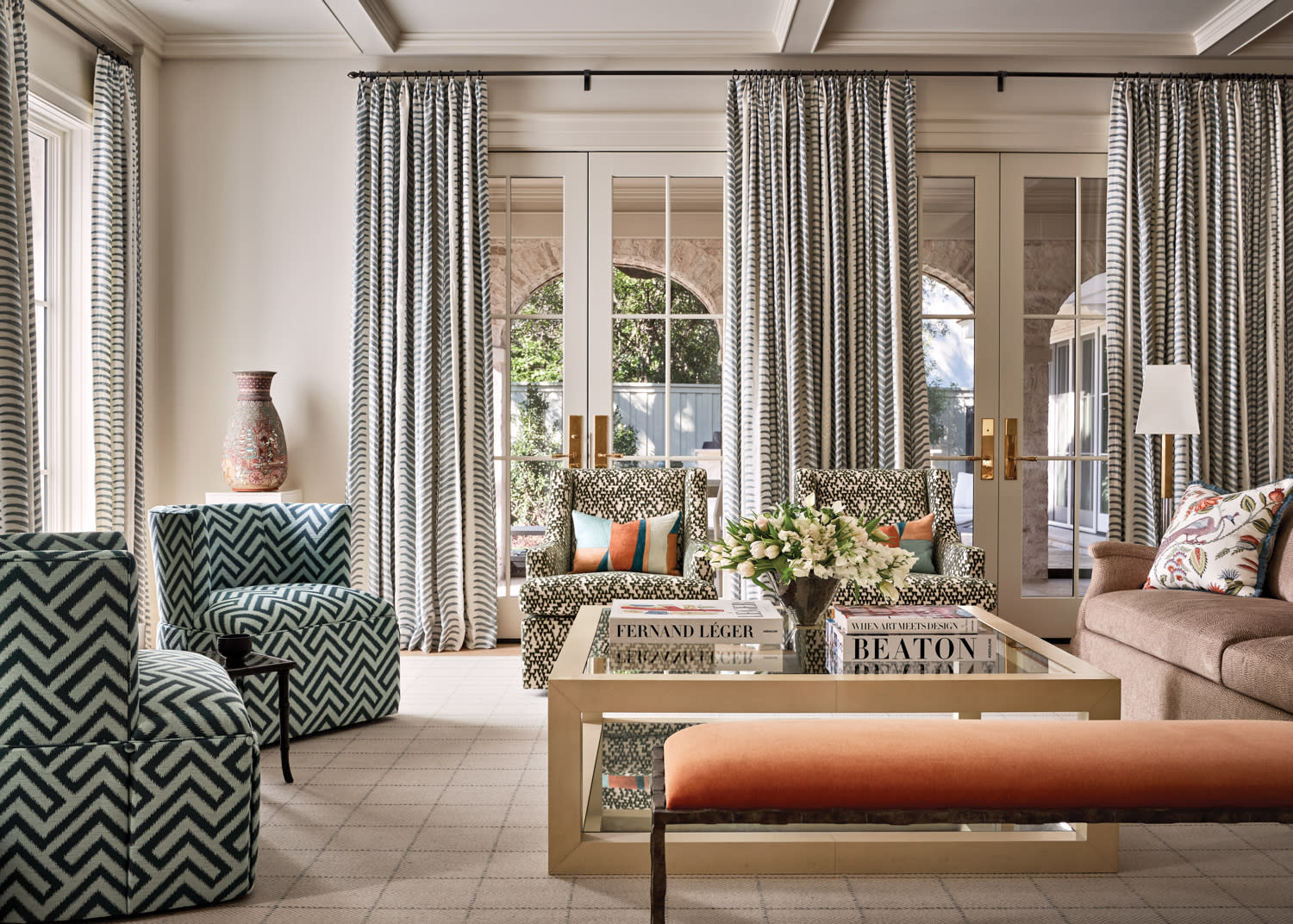 traditional living room with geometric striped armchairs and a glass coffee table