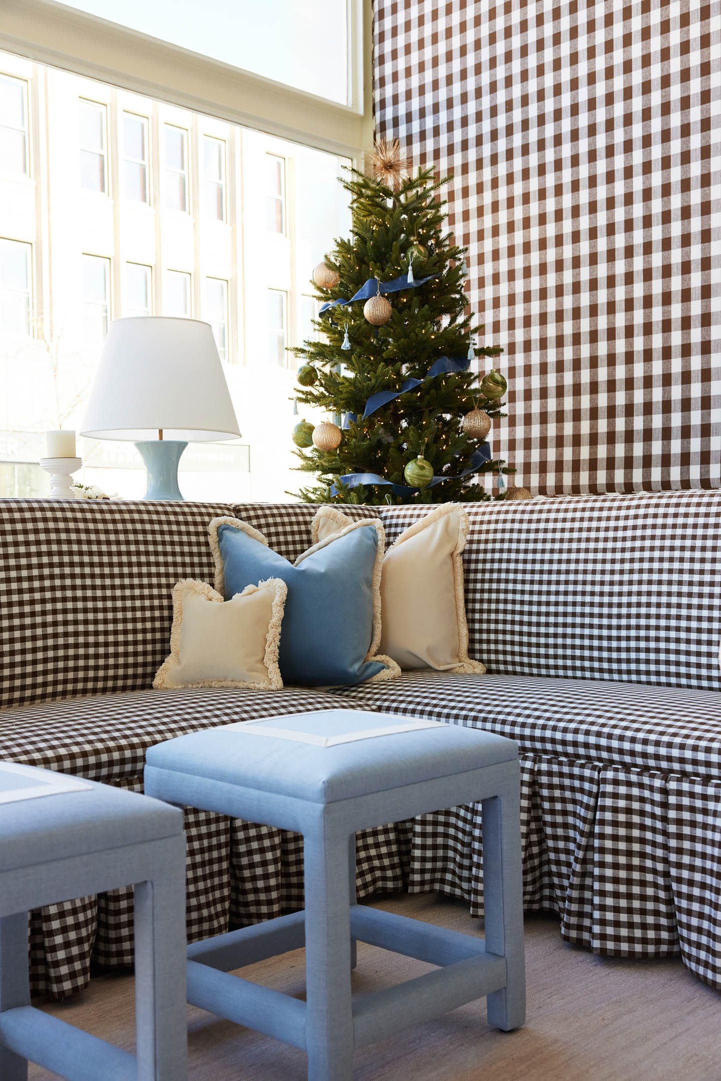 blue footrests sit in front of a gingham sofa