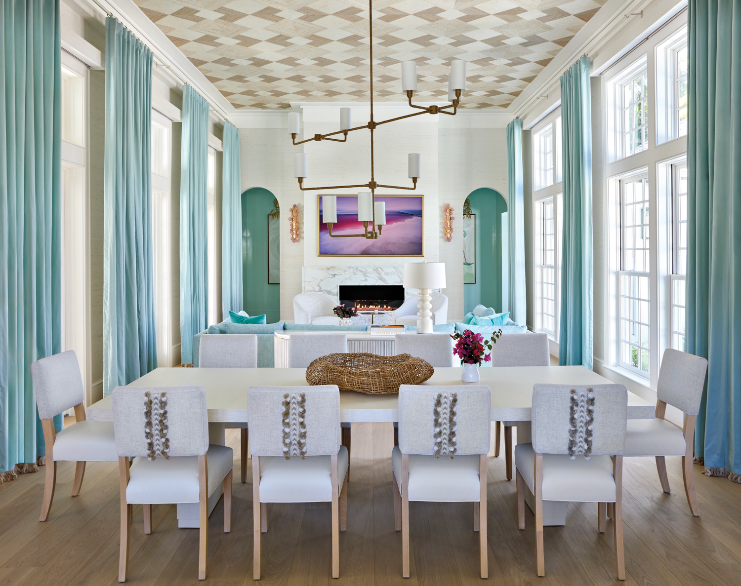 great room with neutral dining chairs and table, armchairs, aqua draperies and matching sofa