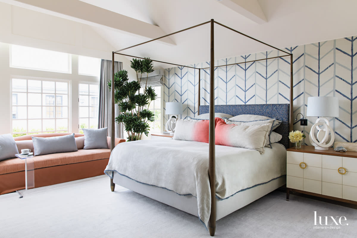 Master bedroom with four poster bed and adjacent sofa