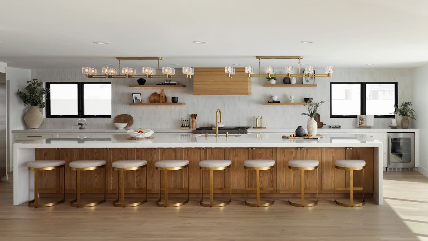 A well-designed kitchen with a prominent island and chic gold stools, offering a blend of functionality and aesthetic appeal.