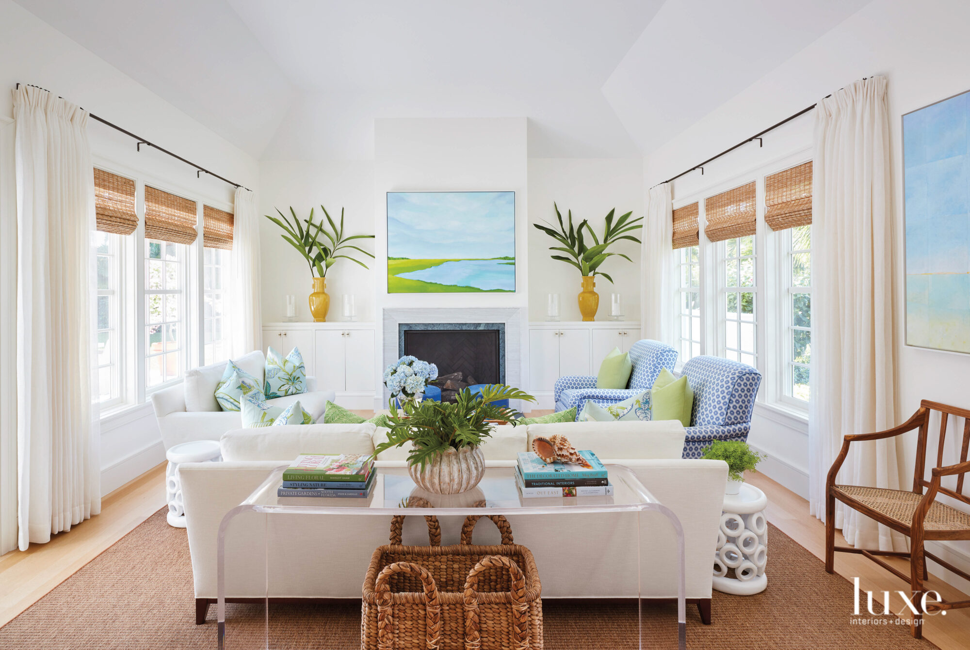 Living room with white sofas and blue and white patterned armchairs.