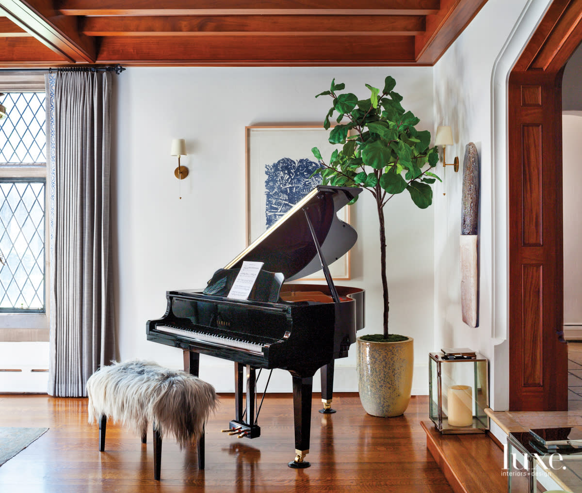 A piano sits in the corner of the living room.