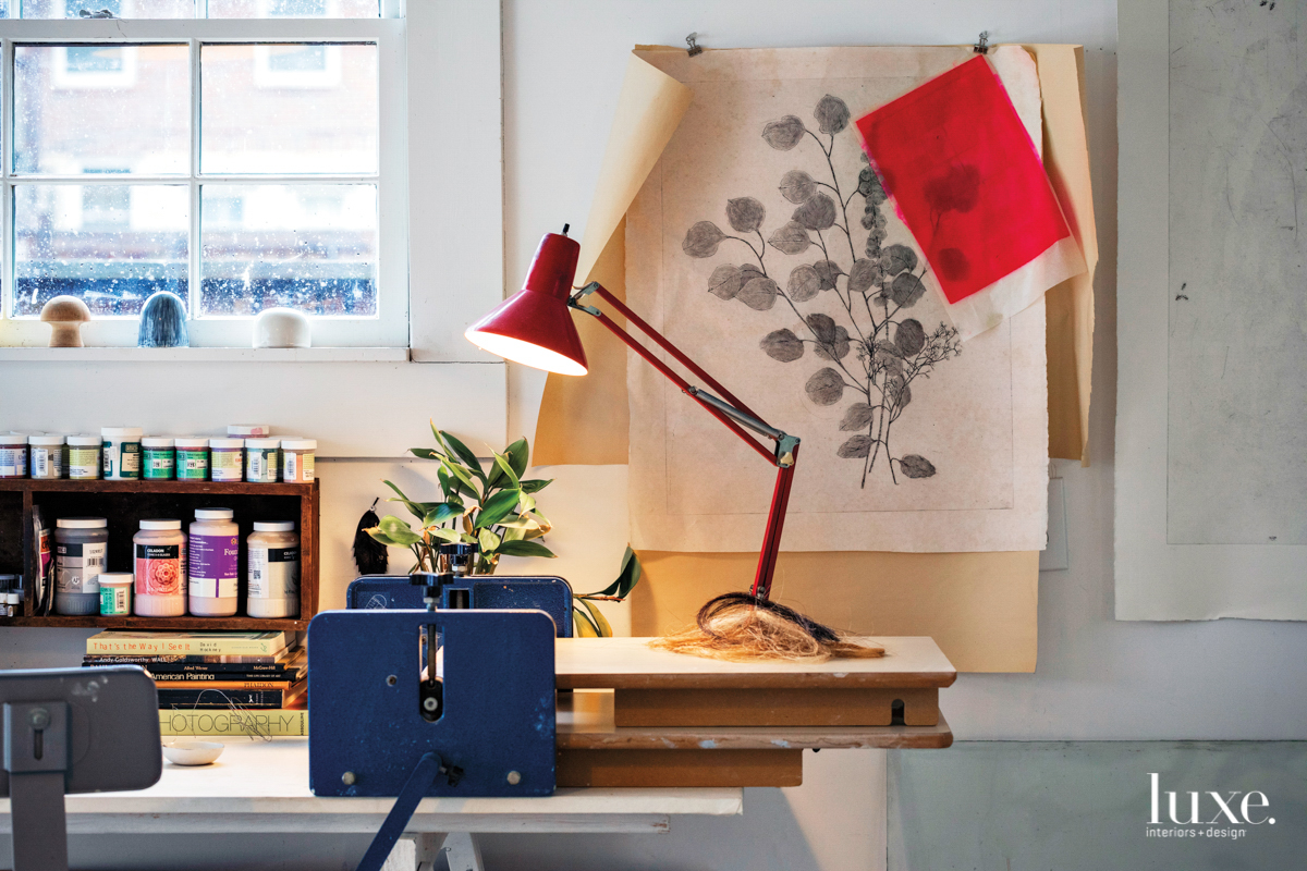 work desk with lamp, botanical artwork and lidded jars