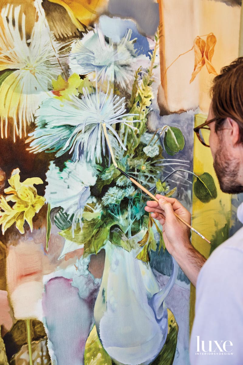 A man painting on a canvase.