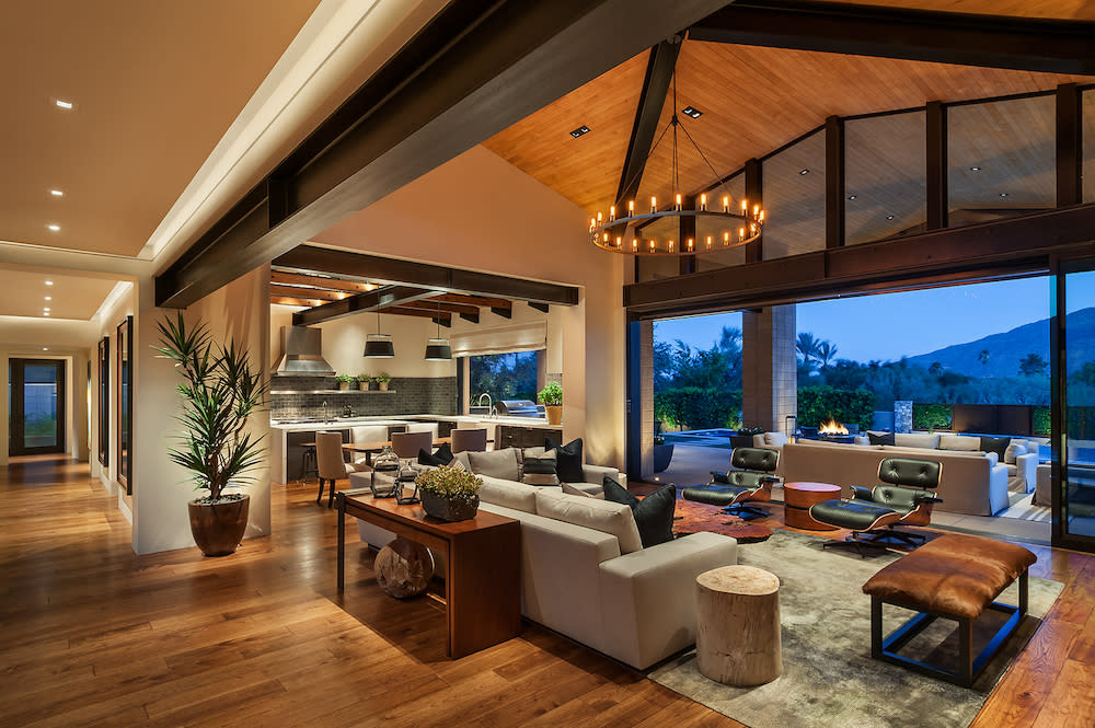 Open living area with wood beam ceiling and decorative chandelier