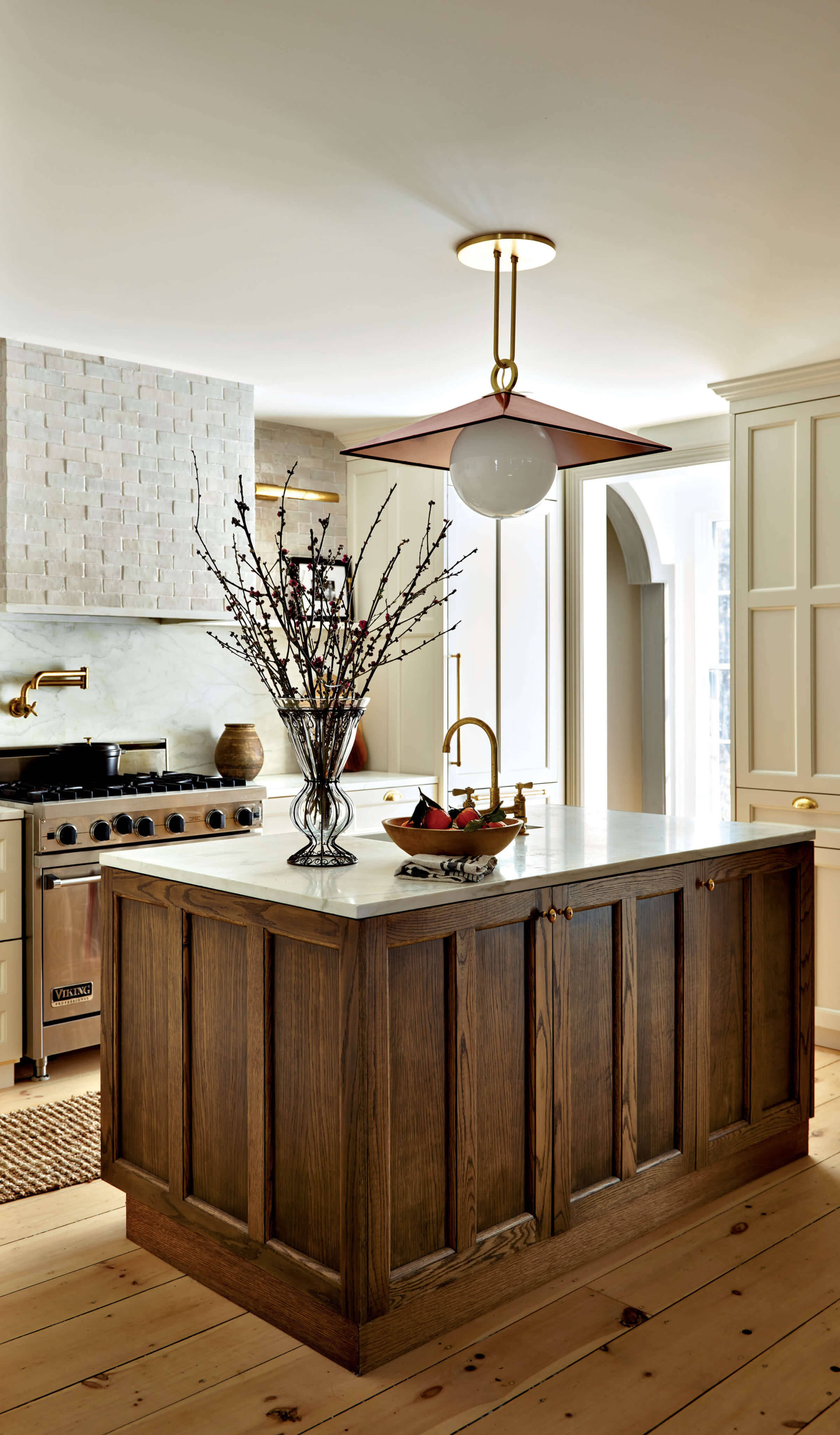 neutral kitchen with a pendant light hanging above an oak island