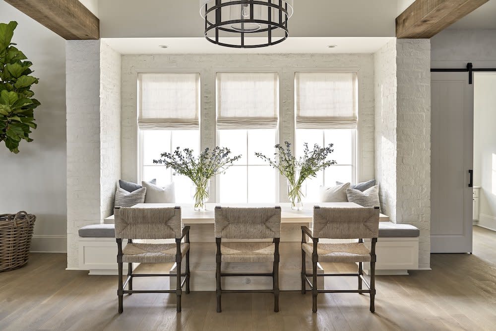 spacious dining room with natural lighting from large windows, dining room table, chairs and round lighting.