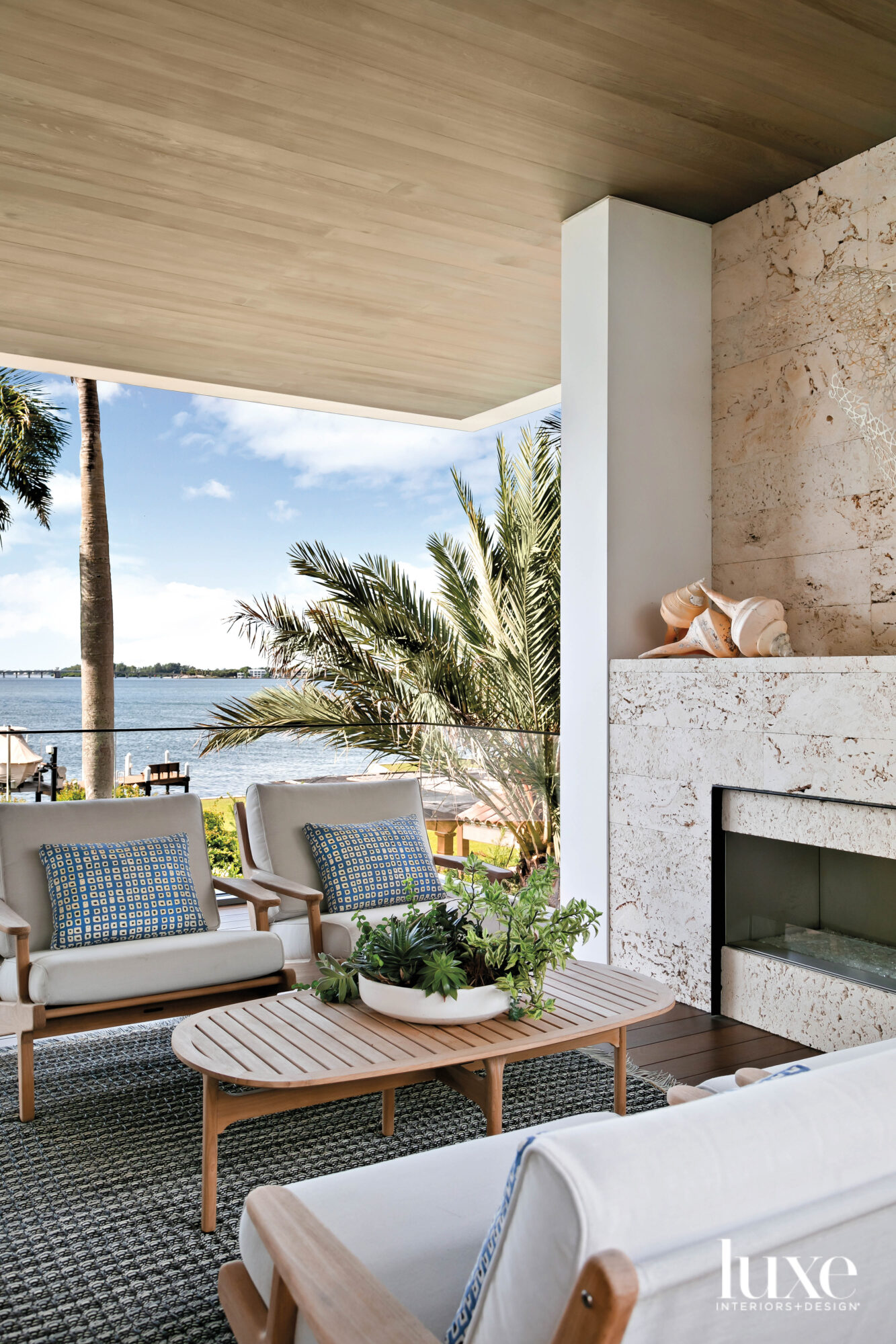 Outdoor seating area with coral stone fireplace and bay views.