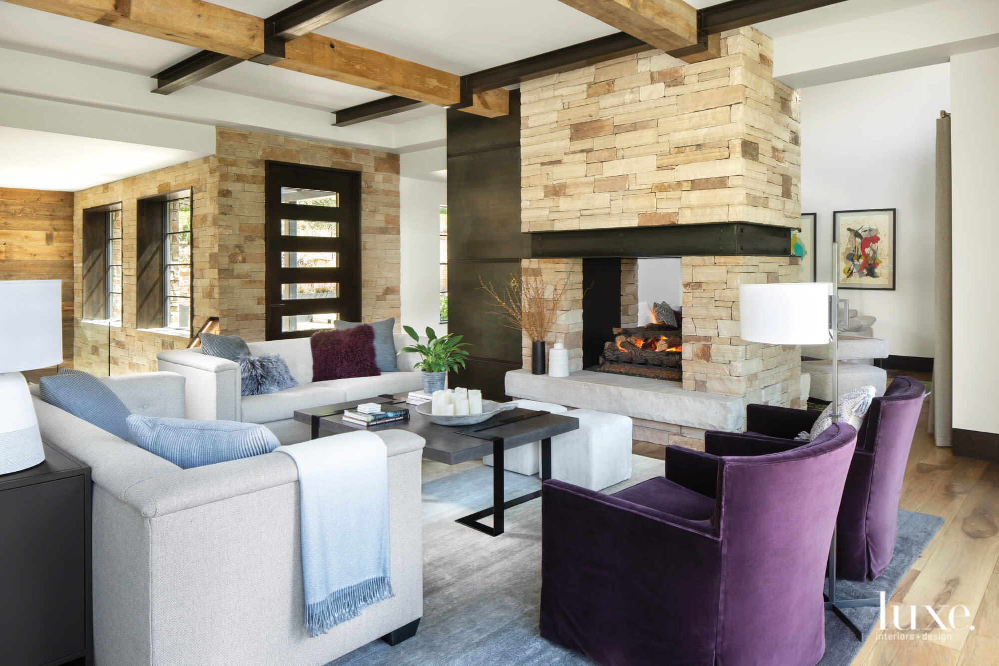 The living room features a large stone-and-metal fireplace.