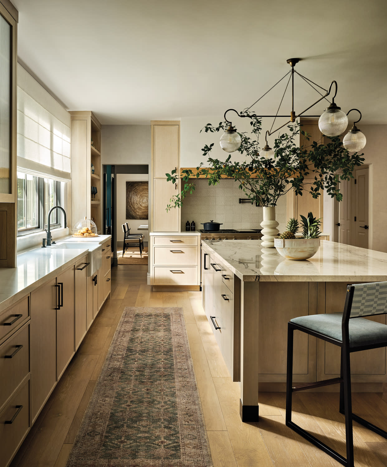 light-filled kitchen with a runner between the cabinetry and island