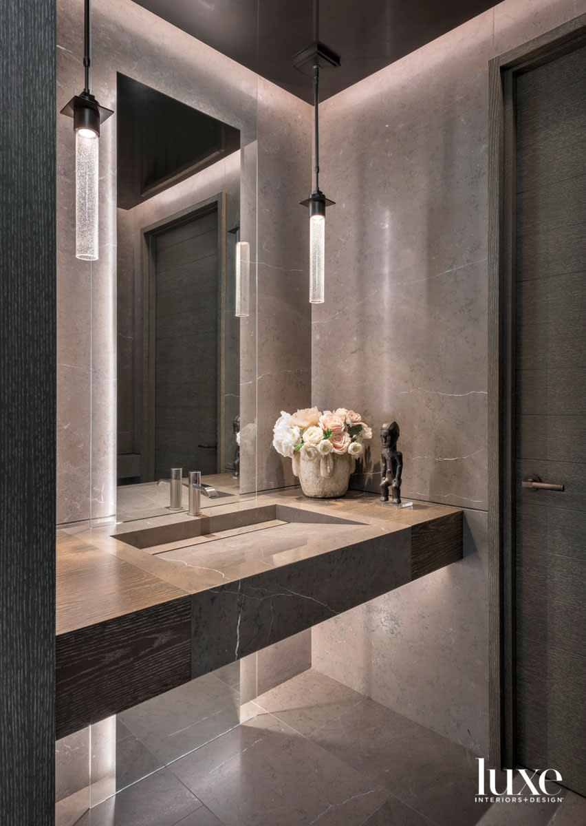 A pair of cylindrical pendants hang in a powder room