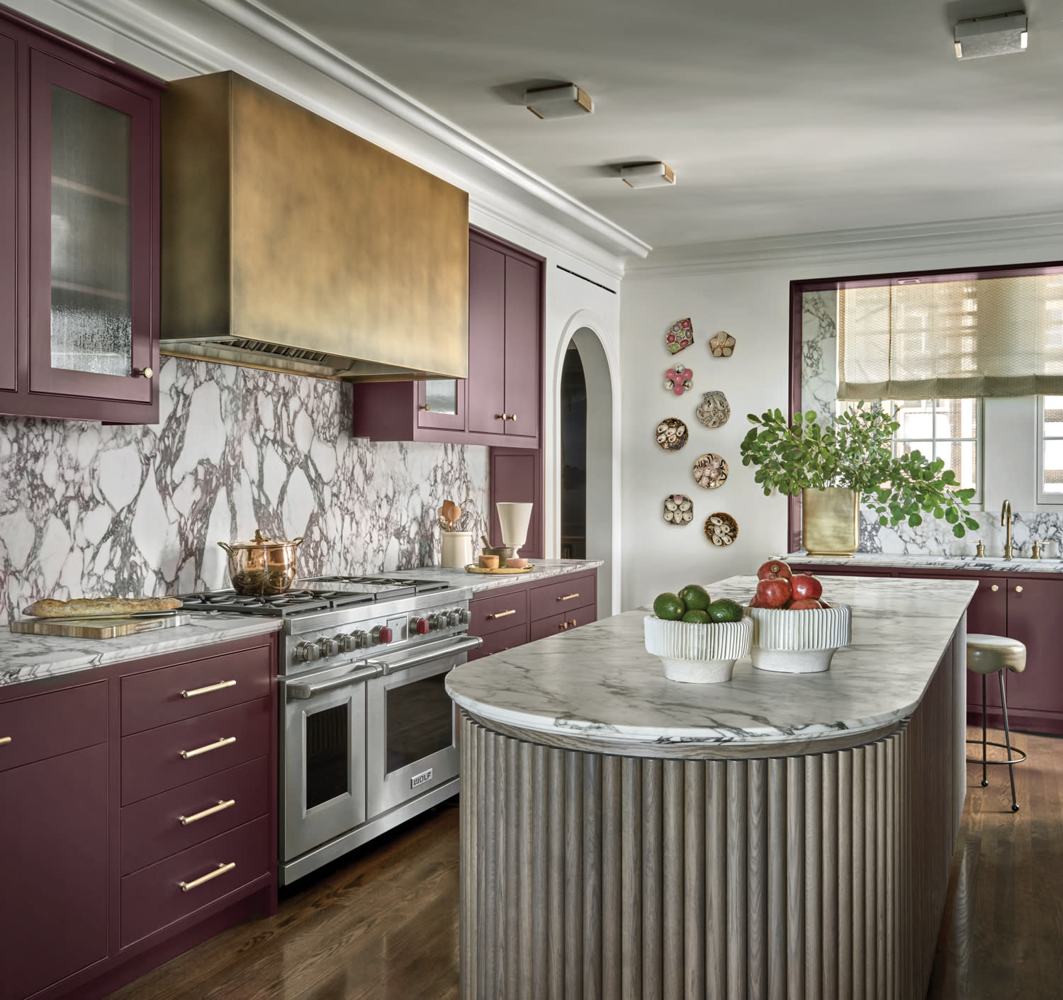 moody kitchen with mauve cabinetry and Calacatta marble backsplash and countertops