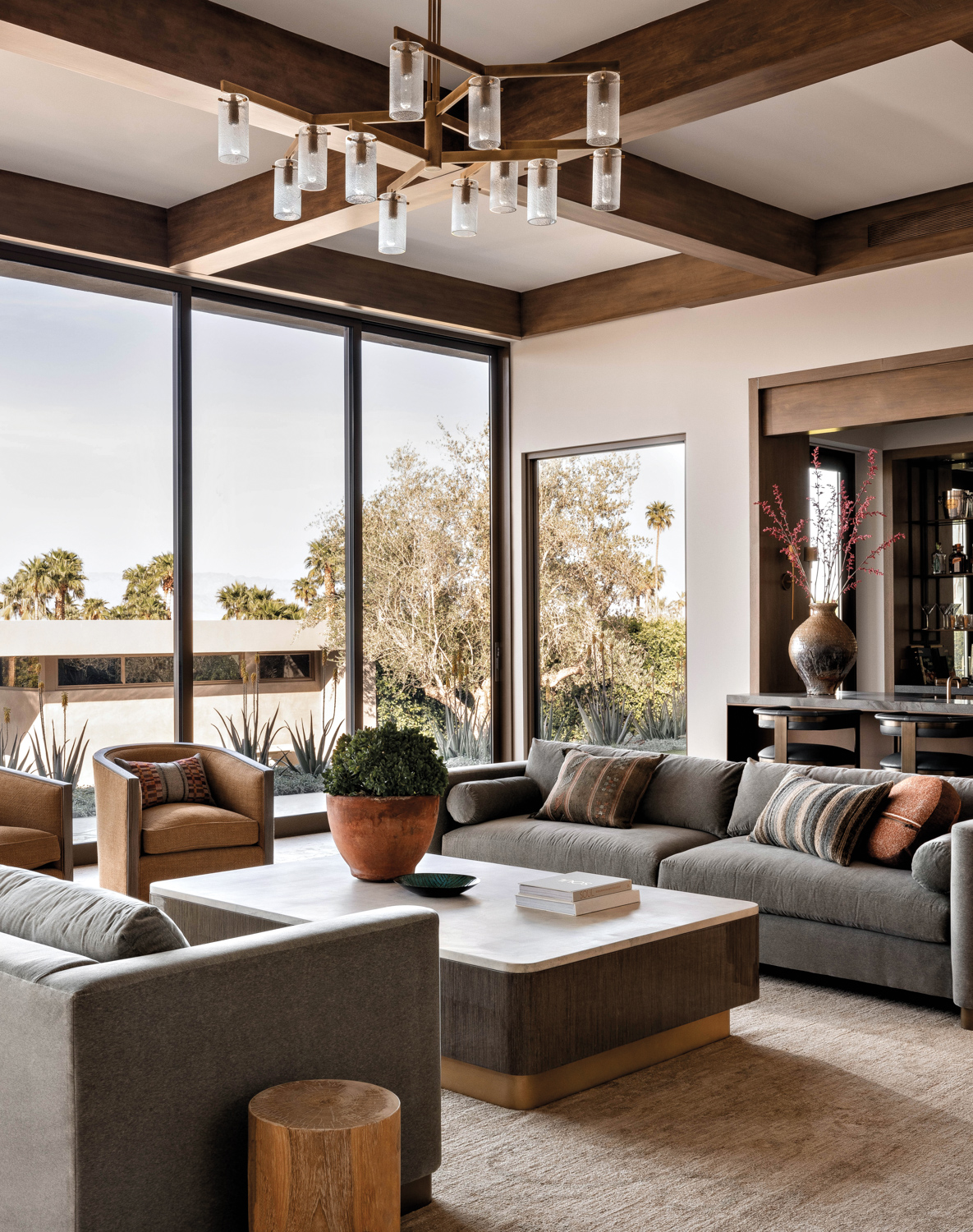 contemporary living room with wall of windows and coffered ceilings with a glass chandelier