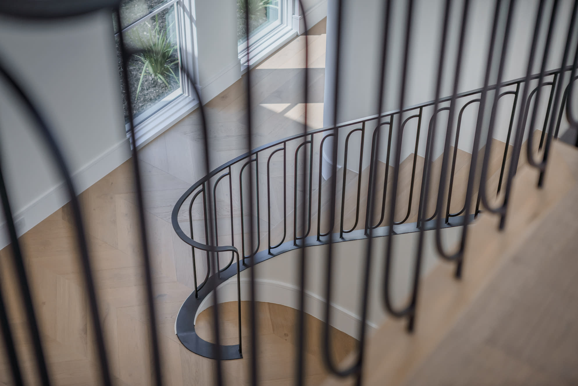 Staircase railing with intricate metal design, featuring swirls and curves for a decorative touch