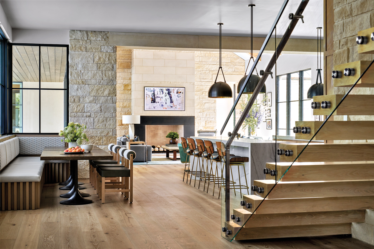 breakfast area with banquette, floating stairs, kitchen and pendant lights