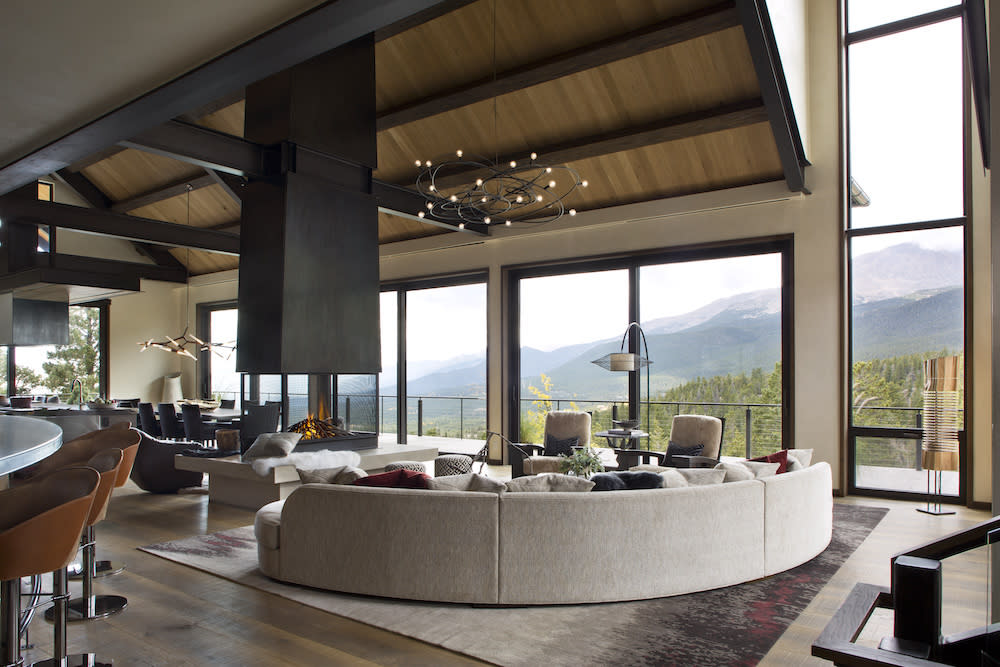 Open entertaining space with center fireplace and mountain views from every direction