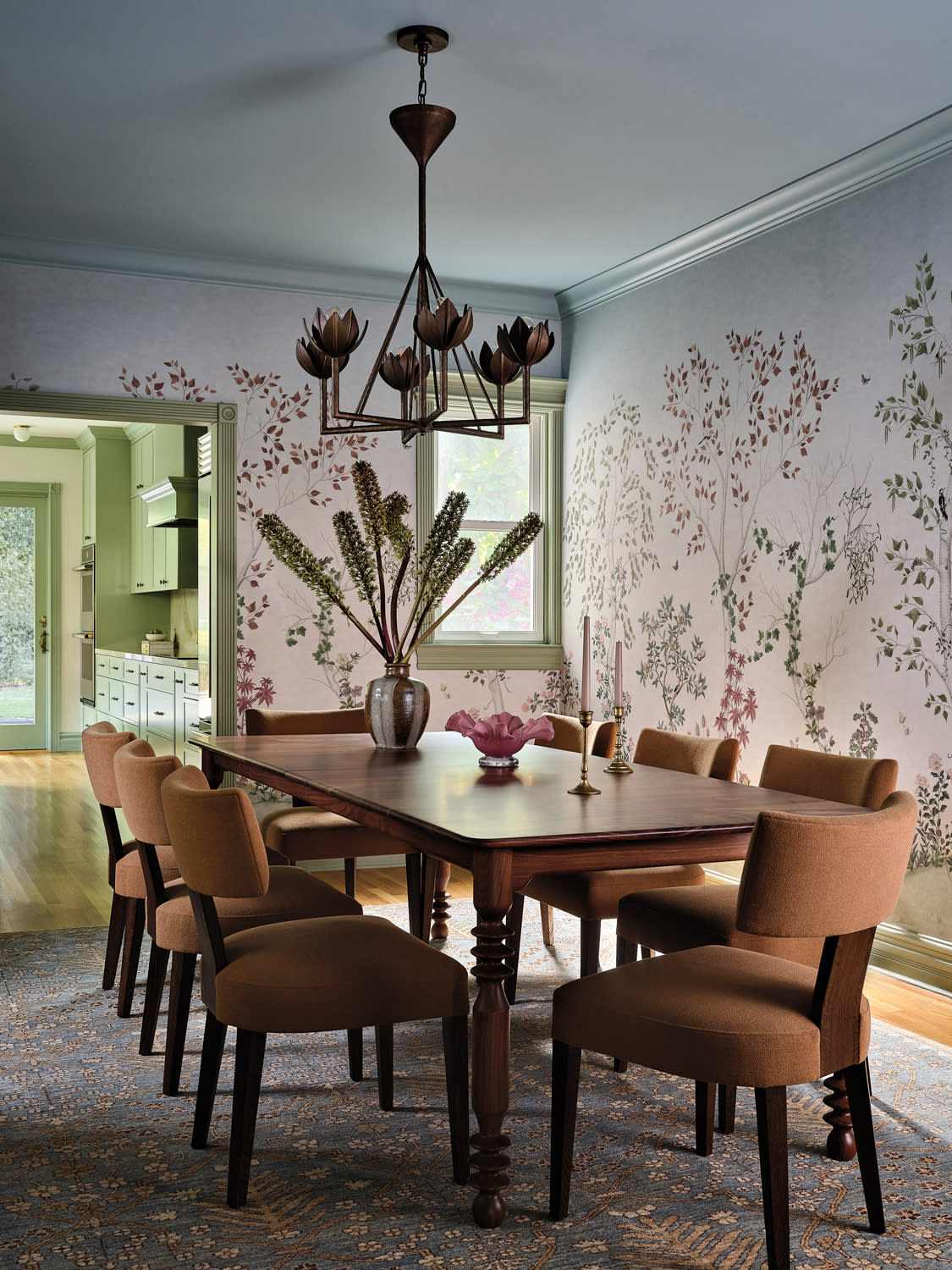 contemporary dining room with a vine-like wallpaper and brown chairs