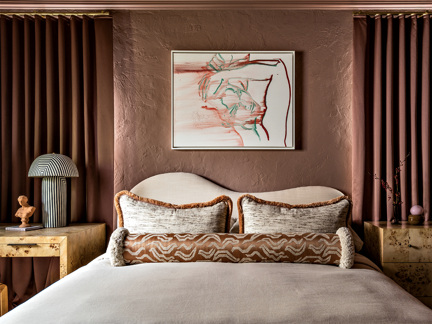 A bed with an angular headboard and white lines sits against a brown wall with matching curtains.
