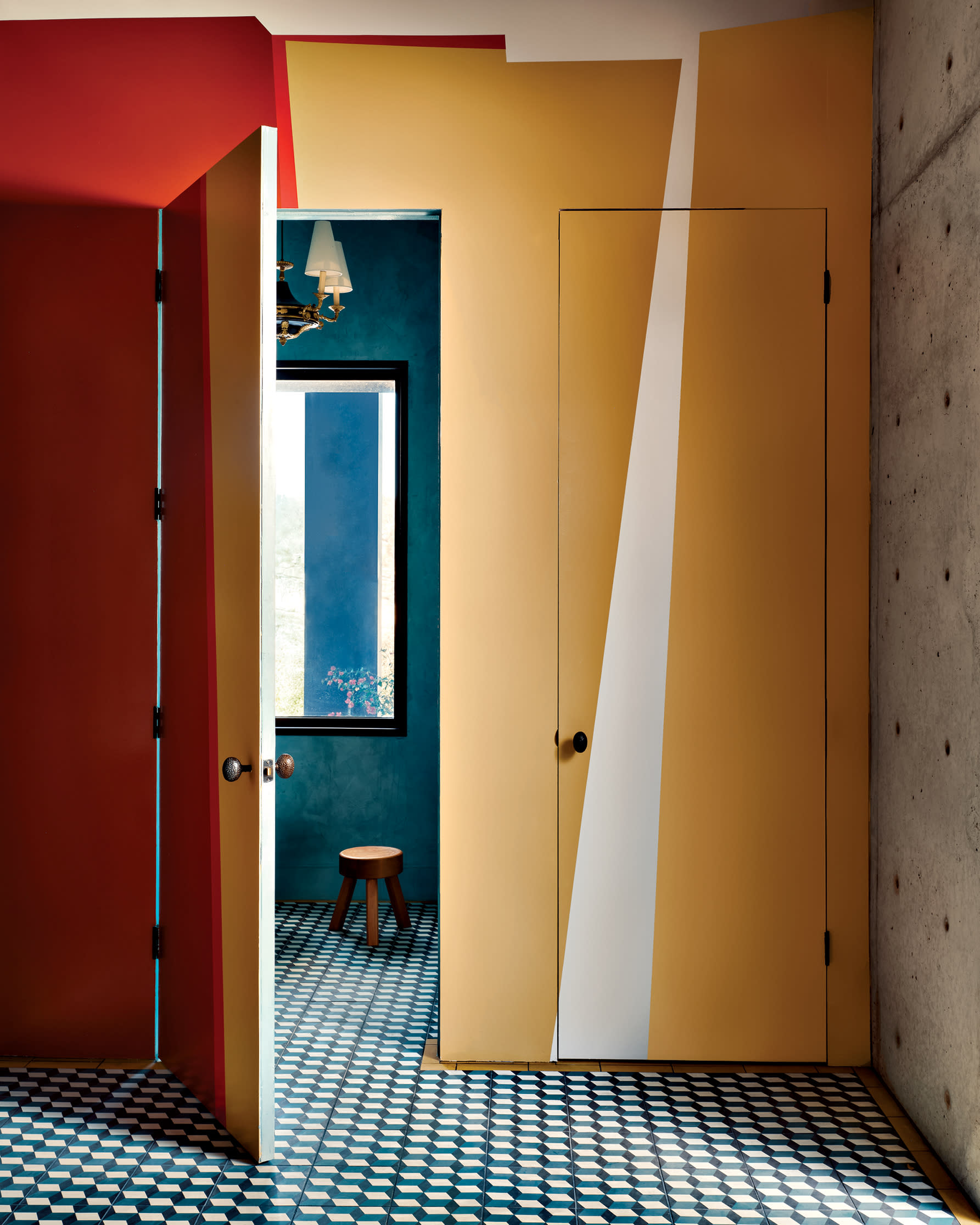 entry vestibule with geometric tile flooring and a red and yellow mural on the walls and door