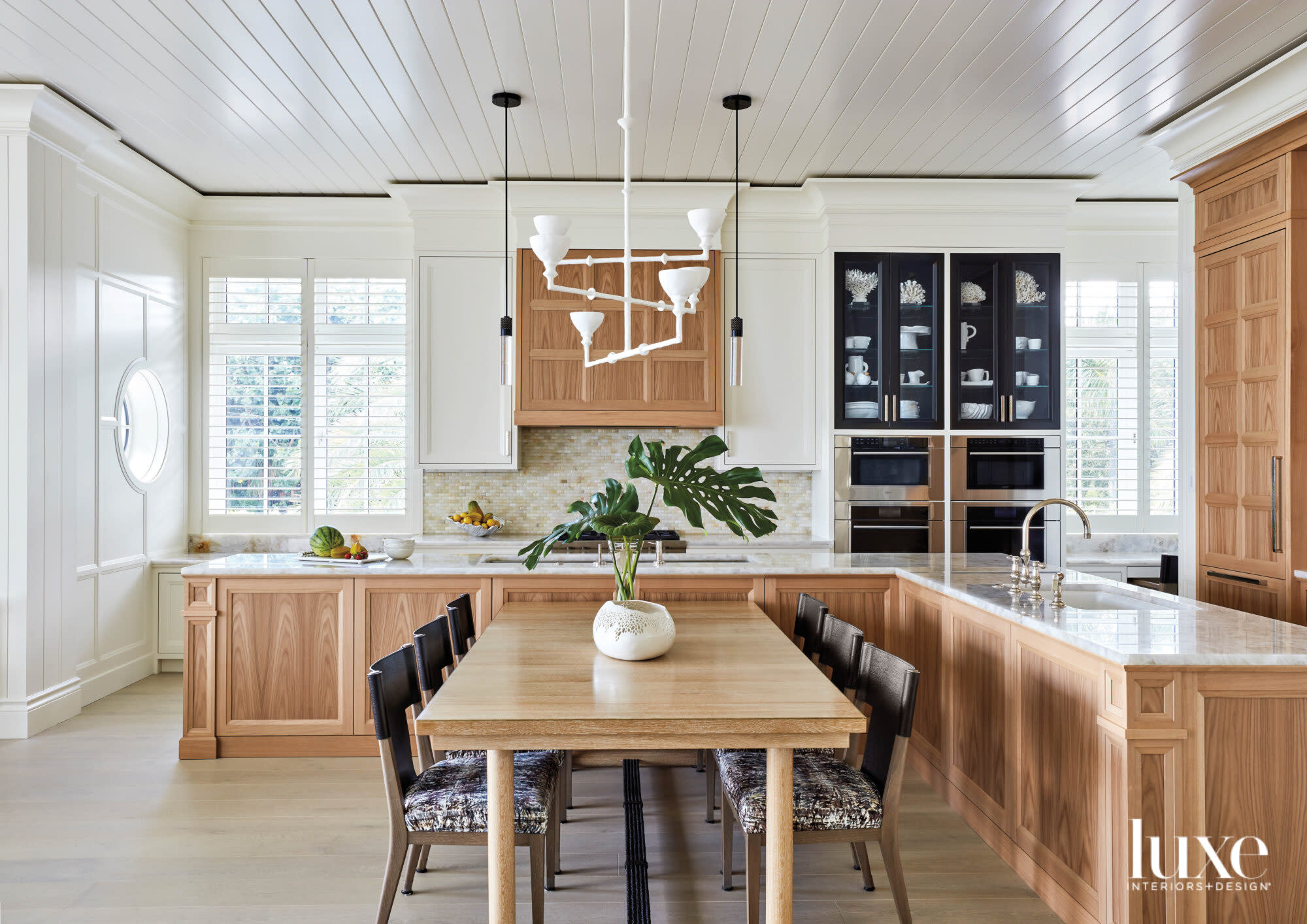 Kitchen with wood cabinetry and a white chandelier.