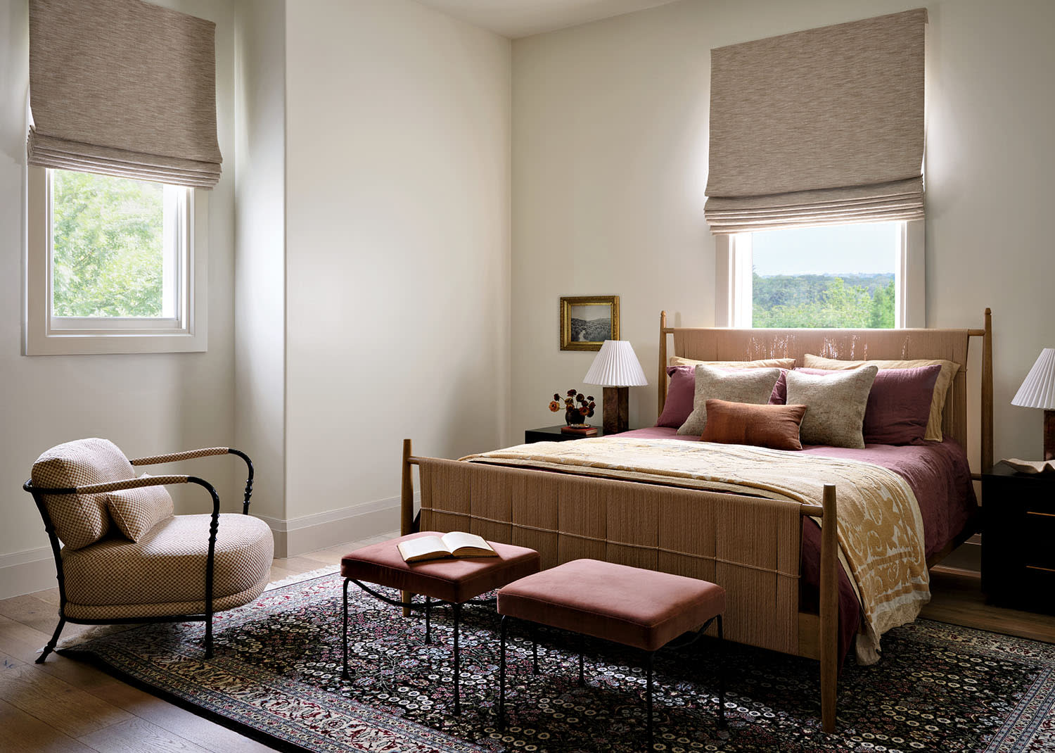 Elegant bedroom with a cozy bed, plush pillows, and warm lamp lighting. Soft tones, patterned rug, and a serene, inviting atmosphere.