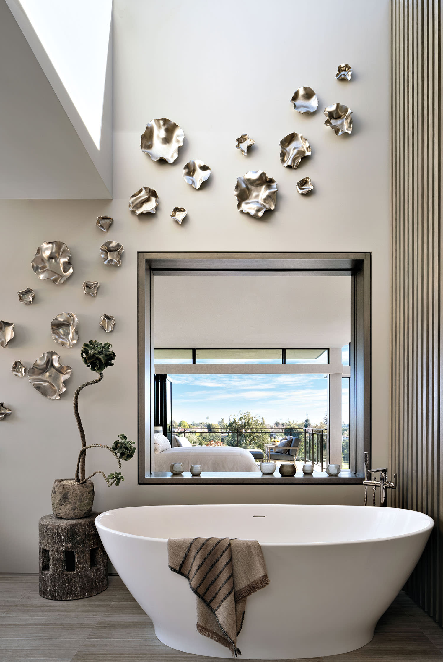 modern bathroom with Ron Dier Design ceramics drifting down the wall above a tub